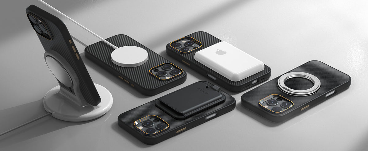 Five black, carbon-fiber patterned iPhones with modular magnetic accessories—chargers, stands, and wallets—are displayed on a light gray surface with soft shadows, highlighting sleek, modern design.