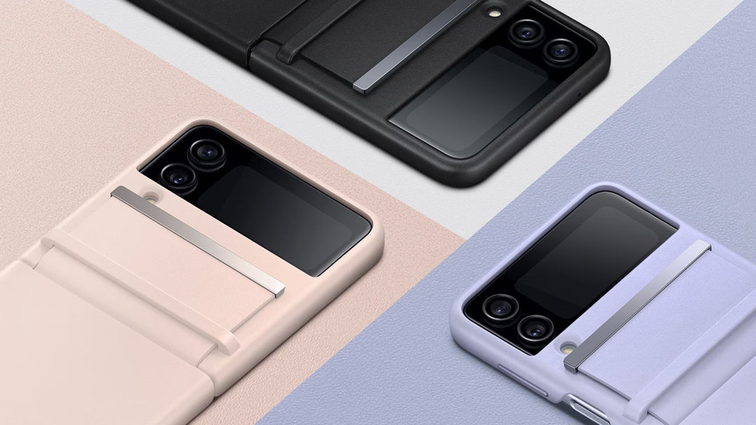Three foldable smartphones in black, pink, and lavender protective cases are displayed diagonally on color-blocked backgrounds. Each phone features a small external screen and dual rear cameras.