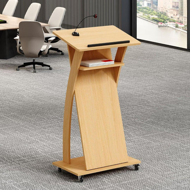 The MobileTechnica Podium Lecturn Rolling Stand features a slanted reading surface with a raised edge, built-in mic, storage shelves, and wheels. It stands in a gray-carpeted conference room with chairs and large windows.