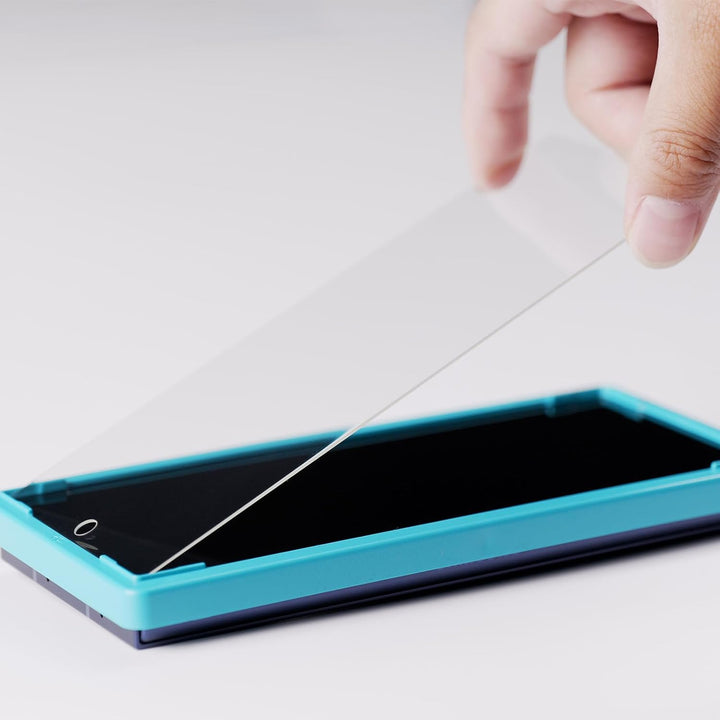 A hand applies a transparent MobileTechnica Samsung Galaxy Z Fold 7 Screen Protector (2 Pack, 9H tempered glass with camera lens protector and alignment frame) onto a phone in a turquoise tray, against a light background.