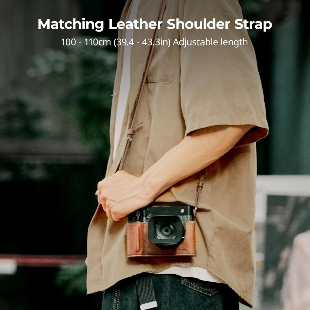 Wearing a light brown short-sleeved shirt and blue jeans, a person carries the SmallRig GFX100RF Leather Case Kit for FUJIFILM GFX100RF (brown) with an adjustable 100–110 cm crossbody strap. Text above highlights the customizable strap length.