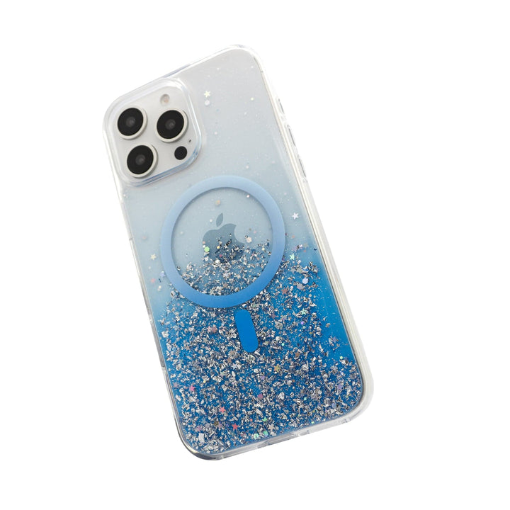 Introducing the Bryten Starburst MagSafe Case for iPhone 16 Pro by Bryten. This transparent case features a circular MagSafe-compatible attachment in the center, with the lower half adorned with blue and silver glitter for a dazzling effect. The iPhone 16 Pro showcases three rear cameras, easily visible along with the Apple logo beneath the circular attachment. Additionally, this case is designed to be anti-yellowing to maintain its pristine look.