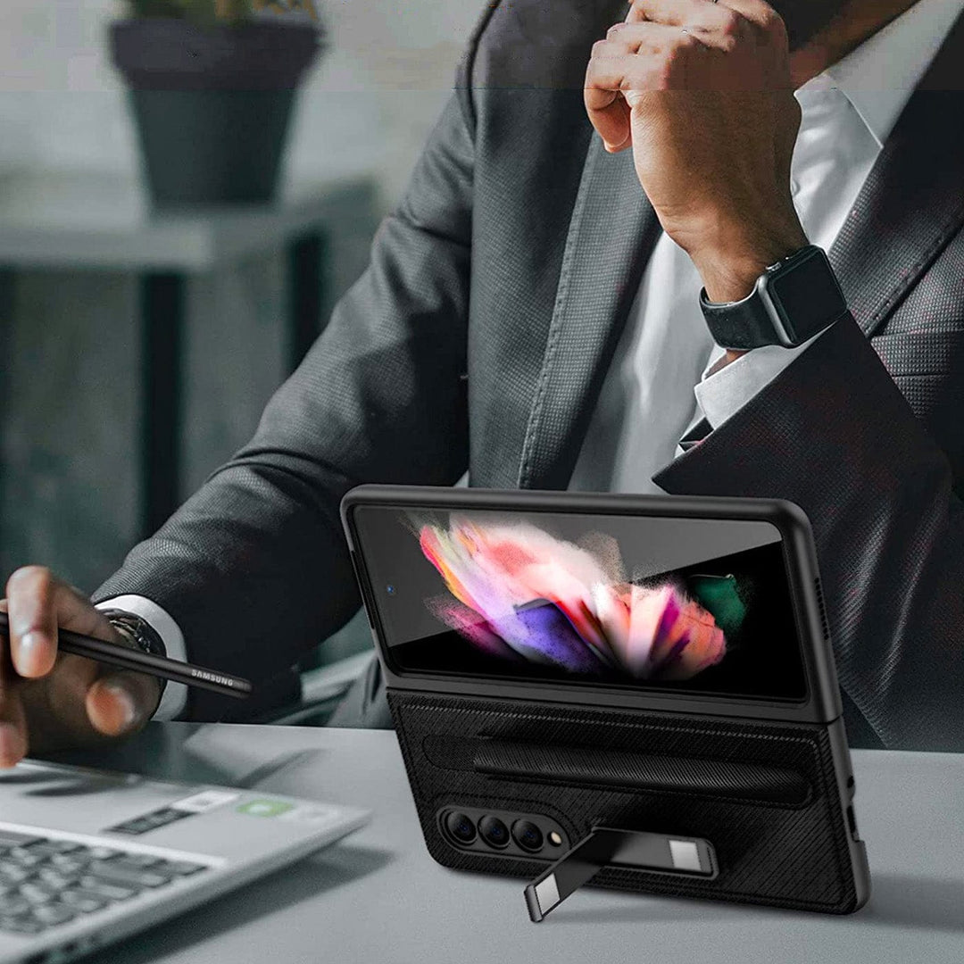 A man in a suit sitting at a desk with a laptop, compatible with the Urban Samsung Galaxy Z Fold 5 Kickstand Case with Pen Holder.